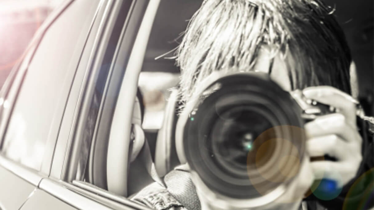 車内からカメラを構える男性の画像